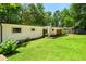 Backyard featuring a spacious lawn, sliding glass doors leading to an outdoor deck and lush surroundings at 1492 Sagewood Cir, Stone Mountain, GA 30083