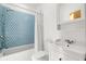 Bright bathroom featuring a bathtub with blue tile and white vanity at 1492 Sagewood Cir, Stone Mountain, GA 30083