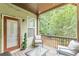 A cozy back porch features outdoor seating, a glass table, green foliage and string lights at 4228 Laurel Creek Se Ct # 6, Smyrna, GA 30080