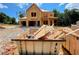 New home under construction with exposed framework and large dumpster in the foreground on a sunny day at 723 Crest Line Trl, Powder Springs, GA 30127