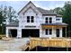 New two-story home under construction featuring a two-car garage and a covered porch at 723 Crest Line Trl, Powder Springs, GA 30127