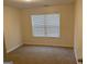 Carpeted bedroom featuring neutral walls, window and a door at 7981 Gossamer Dr, Fairburn, GA 30213