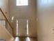 Bright, two-story foyer with hardwood floors, white front door and staircase at 7981 Gossamer Dr, Fairburn, GA 30213