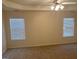 Spacious primary bedroom with carpet, windows and ceiling fan at 7981 Gossamer Dr, Fairburn, GA 30213