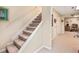 Carpeted basement stairs leading to a finished basement with carpeted floors and white walls at 1625 Rushing River Way, Suwanee, GA 30024
