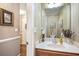 Powder room featuring a single sink vanity with wallpaper and hardwood floors at 1625 Rushing River Way, Suwanee, GA 30024