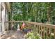 Outdoor deck with wooden railing overlooking the backyard featuring various potted flowers at 1625 Rushing River Way, Suwanee, GA 30024