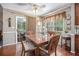 Cozy dining area features wood floors, a ceiling fan, and a view to the sunroom at 1625 Rushing River Way, Suwanee, GA 30024