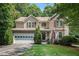 Charming two-story home featuring a well-manicured lawn, a two-car garage, and a welcoming front porch at 1625 Rushing River Way, Suwanee, GA 30024