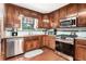 Functional kitchen boasting stainless steel appliances, wooden cabinets, and tiled backsplash at 1625 Rushing River Way, Suwanee, GA 30024
