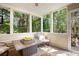 Cozy sunroom featuring many windows, a comfortable chair, and a view of the backyard at 1625 Rushing River Way, Suwanee, GA 30024