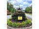 View of the entrance to the community with brick pillars, manicured landscaping, and a decorative weather vane at 333 Lauren Ln, Woodstock, GA 30188