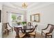Formal dining room with chandelier, tray ceiling and large window views at 333 Lauren Ln, Woodstock, GA 30188