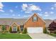 Charming brick home featuring an attached two-car garage, manicured lawn, and mature landscaping at 333 Lauren Ln, Woodstock, GA 30188