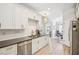 Well-lit kitchen featuring white cabinets, stainless steel appliances, and dark countertops at 333 Lauren Ln, Woodstock, GA 30188