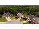 Aerial view of homes and manicured landscaping in a suburban neighborhood with mature trees and a pond at 638 Glen Valley Way, Dacula, GA 30019