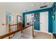 Bright hallway with neutral carpeting, blue accent wall, and wood railing on the staircase at 638 Glen Valley Way, Dacula, GA 30019