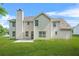 View of the home's backyard and facade featuring a patio, chimney, and green lawn at 6799 Hill Creek Cv, Lithonia, GA 30058