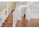 Bright foyer with hardwood floors, staircase, and view into the living room at 6799 Hill Creek Cv, Lithonia, GA 30058