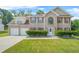 Charming two-story brick home featuring a manicured lawn, red shutters, and a two-car garage at 6799 Hill Creek Cv, Lithonia, GA 30058