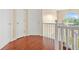 Upstairs hallway featuring hardwood floors, a window, and access to bedrooms, creating a seamless flow at 6799 Hill Creek Cv, Lithonia, GA 30058