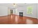 Spacious living room with hardwood flooring and a cozy fireplace, bathed in natural light from surrounding windows at 6799 Hill Creek Cv, Lithonia, GA 30058