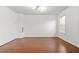 Open-concept living room with hardwood floors, crown molding, and a large window at 6799 Hill Creek Cv, Lithonia, GA 30058