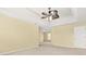 Expansive primary bedroom with a tray ceiling, ceiling fan, and neutral carpeting at 6799 Hill Creek Cv, Lithonia, GA 30058