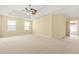 A large primary bedroom with neutral carpeting and a stylish ceiling fan for added comfort at 6799 Hill Creek Cv, Lithonia, GA 30058