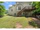 Exterior view of the back of the house shows a deck, staircase, and a lush green yard at 194 Lake Ruby Dr, Suwanee, GA 30024