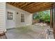 A covered back patio with a door and window to the basement provides an outdoor seating and entertaining area at 194 Lake Ruby Dr, Suwanee, GA 30024