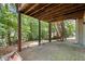 Covered back patio view shows mature trees, wooded backyard, and stairs leading to the upper deck at 194 Lake Ruby Dr, Suwanee, GA 30024