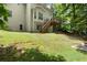 Large grassy backyard with stairs to the back deck and wooded boundary line at 194 Lake Ruby Dr, Suwanee, GA 30024