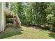 Large grassy backyard with stairs to the back deck and an outdoor fire pit area for entertaining at 194 Lake Ruby Dr, Suwanee, GA 30024
