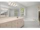 Bright bathroom with a soaking tub, a double sink vanity, and tiled floors at 194 Lake Ruby Dr, Suwanee, GA 30024