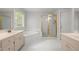 Bright bathroom with a soaking tub, tiled floors, and a glass-enclosed shower at 194 Lake Ruby Dr, Suwanee, GA 30024