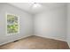 Empty bedroom with neutral walls, window, and tile flooring at 194 Lake Ruby Dr, Suwanee, GA 30024