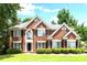 Stunning two-story red brick home featuring manicured lawn and lush landscaping at 194 Lake Ruby Dr, Suwanee, GA 30024