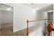 Bright hallway with wood railing, neutral walls, and open doorway to a bedroom at 194 Lake Ruby Dr, Suwanee, GA 30024
