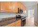 Close-up of the kitchen's stainless steel appliances, wood cabinets, and granite countertops at 194 Lake Ruby Dr, Suwanee, GA 30024