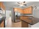 Kitchen featuring wood cabinets, stainless steel appliances, granite countertops, tile floor and a ceiling fan at 194 Lake Ruby Dr, Suwanee, GA 30024