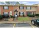 Charming brick townhome featuring black shutters, a landscaped yard, and convenient parking at 382 Northdale Ct, Lawrenceville, GA 30046