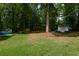 Large, grassy backyard with a storage shed, surrounded by mature trees and providing ample space at 402 Princeton Way, Lawrenceville, GA 30044