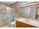 Bathroom featuring neutral tile, a glass shower, and a wood vanity at 402 Princeton Way, Lawrenceville, GA 30044