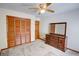 Empty bedroom with wooden closet and drawers with a ceiling fan and neutral carpet at 402 Princeton Way, Lawrenceville, GA 30044