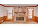 Living room displaying a stone fireplace with a wooden mantel, flanked by two windows at 402 Princeton Way, Lawrenceville, GA 30044