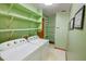 Bright laundry room with green walls, open shelving, and modern appliances at 402 Princeton Way, Lawrenceville, GA 30044