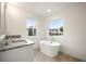 Bathroom featuring granite countertops, dual sinks, large tub, and natural light from windows at 4095 Oriole Ln, Fairburn, GA 30213