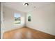 A bright, empty bedroom with wood-look flooring and two windows offering neighborhood views at 4095 Oriole Ln, Fairburn, GA 30213
