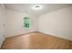 An empty bedroom with wood-look flooring, a single window, and neutral walls awaits your personal touch at 4095 Oriole Ln, Fairburn, GA 30213